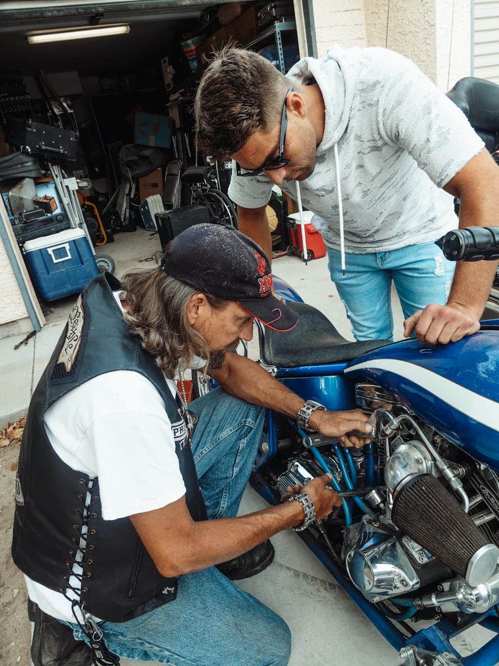 man in white crew neck t shirt and blue denim jeans sitting on blue and black
